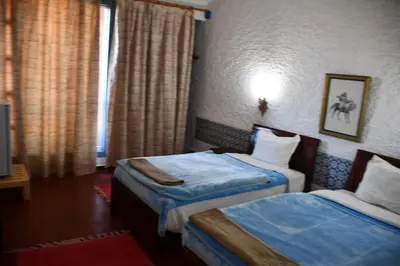 a hotel room with two beds and a window at Hôtel Rose Mgouna in Kalaat MGouna
