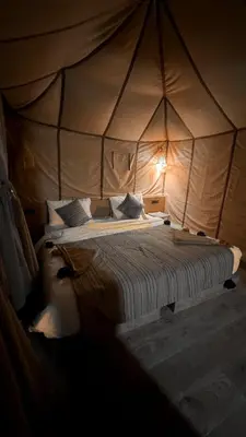 a bedroom with a bed in a tent at Merzouga Chic Luxury Camps in Merzouga