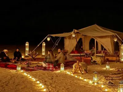 a group of people sitting in front of a tent at Erg Chebbi Desert Glamping in Merzouga