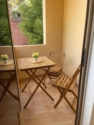 a wooden table and chairs in a room with a window at Dar Itri in Ourika