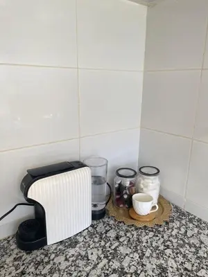a kitchen counter with a toaster and some jars and cups at Dar Itri in Ourika