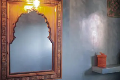 a large mirror on a wall next to a vase at Palm View Palace in Ouarzazate