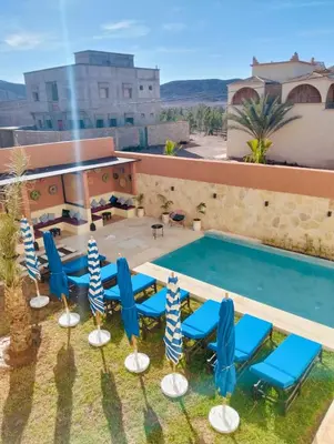 a swimming pool with blue chairs and a swimming pool at Palm View Palace in Ouarzazate