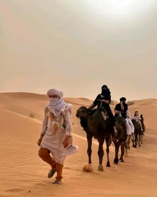 a group of people riding horses in the desert at Merzouga sultana luxury tent in Merzouga