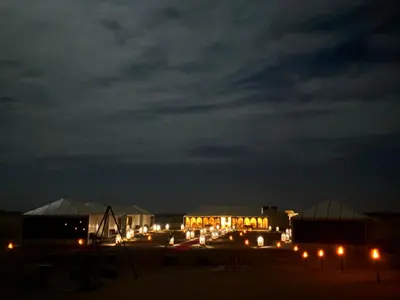 a group of buildings lit up at night at Merzouga sultana luxury tent in Merzouga