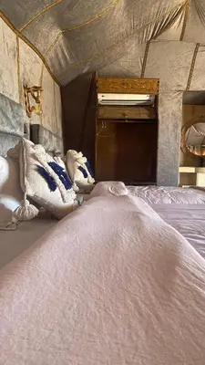 a large white bed in a room with a ceiling at Merzouga sultana luxury tent in Merzouga