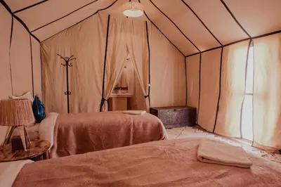 a room with two beds in a tent at Merzouga Glossy Camp in Merzouga