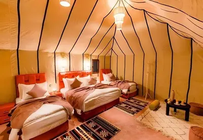 a bedroom with two beds in a tent at Merzouga Glossy Camp in Merzouga
