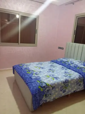 a bedroom with a bed with a blue blanket at Appartement in Fès
