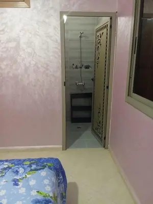 a bathroom with a walk in shower and a doorway at Appartement in Fès