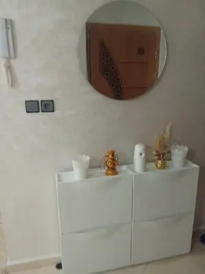 a mirror on a wall above a white dresser at Appartement in Fès