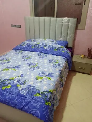a bed in a room with a blue comforter at Appartement in Fès
