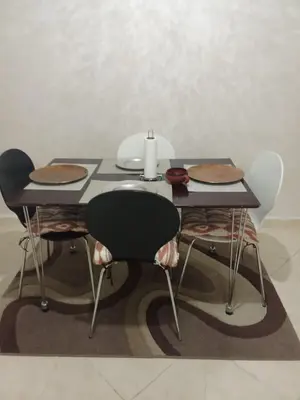 a table with four chairs and a candle on it at Appartement in Fès