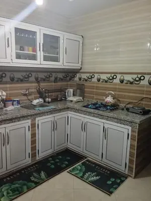 a kitchen with white cabinets and a counter top at Appartement in Fès