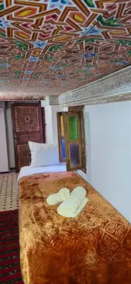 a bedroom with a bed with a patterned ceiling at Dar Amazigh in Fès