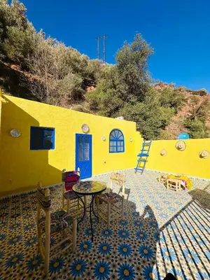 a yellow house with a table and chairs in front of it at Maison Berber in Ourika
