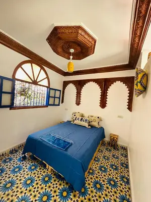 a bedroom with a blue bed and a blue and white floor at Maison Berber in Ourika