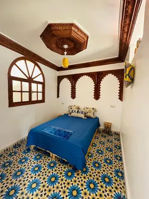 a bedroom with a blue bed with blue and white tiles at Maison Berber in Ourika
