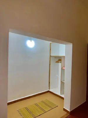 an empty room with a white wall and a door at Hôtel Khalwa in Jenane Sidi Amer