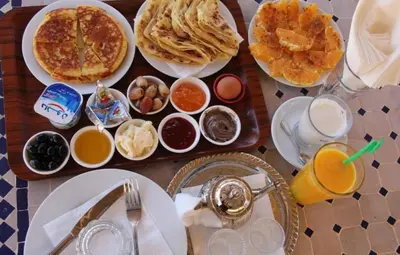 a table with a tray of breakfast foods and drinks at Private Luxury Camp in Merzouga