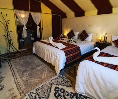 two beds with swans on them in a room at Private Luxury Camp in Merzouga