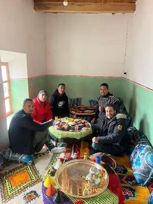 a group of men sitting around a table in a room at Dar Ayoub in Inlghdene