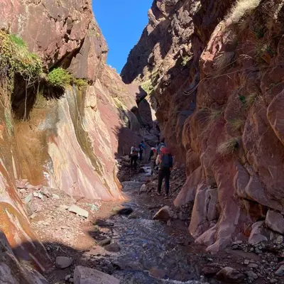 a group of people walking through a canyon at Dar Ayoub in Inlghdene