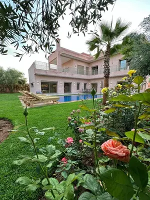 a house with a yard with flowers and a pool at Villa Bellevue in Sbiti