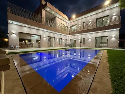 a swimming pool in front of a house at night at Villa Bellevue in Sbiti