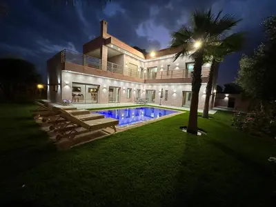 a house with a swimming pool and a palm tree at Villa Bellevue in Sbiti