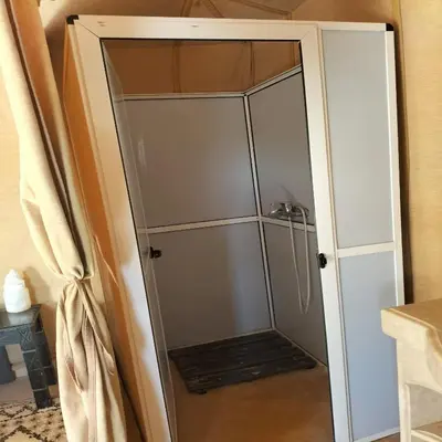 a shower stall with a glass door at Magnifique Luxury Camp in Merzouga