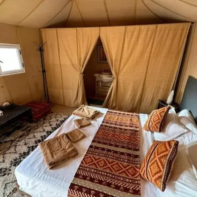 a bedroom with a bed in a tent at Magnifique Luxury Camp in Merzouga