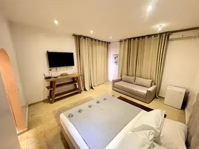 a bedroom with a large bed and a television at Maison d 'Hôtes de Charme 7 Ch in Sidi Bouzguia