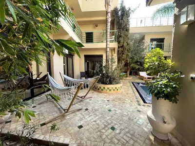 a courtyard with chairs and a swimming pool in a house at Maison d 'Hôtes de Charme 7 Ch in Sidi Bouzguia