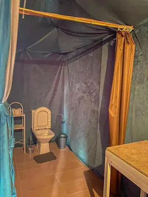 a bathroom with a toilet in a tent at Tenere desert luxury camp in Merzouga