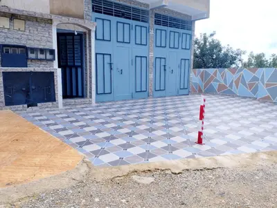 a house with a checkered floor in front of a garage at Gite touristique bouknala in Abinane