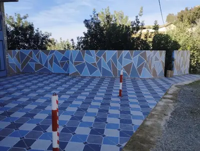 a blue and white tiled driveway with a fence at Gite touristique bouknala in Abinane
