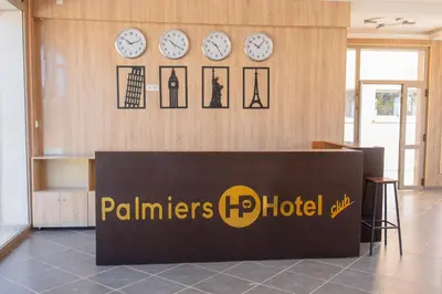 a hotel lobby with clocks on the wall at Palmiers Hôtel Club in Er Rachidia