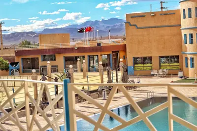 a view of a resort with mountains in the background at Palmiers Hôtel Club in Er Rachidia