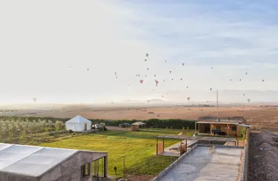a group of kites flying in the sky over a field at Getaway between nature and adventure in Marrakech