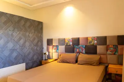 a bedroom with a bed and a wall with paintings at Getaway between nature and adventure in Marrakech
