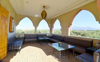 a restaurant with benches and tables and windows at Jnane az Zatr Villa and pool Ourika in Ourika