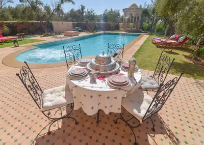 a table with a tea pot on it next to a pool at Jnane az Zatr Villa and pool Ourika in Ourika