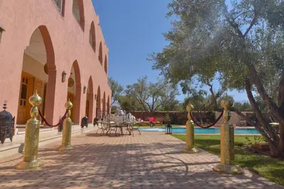 a brick walkway next to a building with a pool at Jnane az Zatr Villa and pool Ourika in Ourika