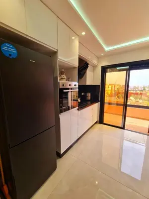a kitchen with black appliances and a large window at Lusail in Beni Mellal