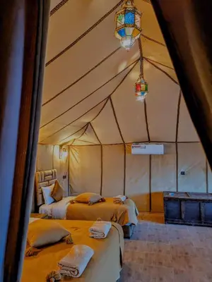 a room with two beds in a tent at Glamping Dunes Merzouga in Merzouga