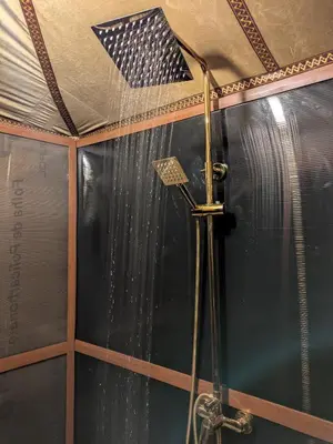 a shower in a room with a flag on the ceiling at Glamping Dunes Merzouga in Merzouga