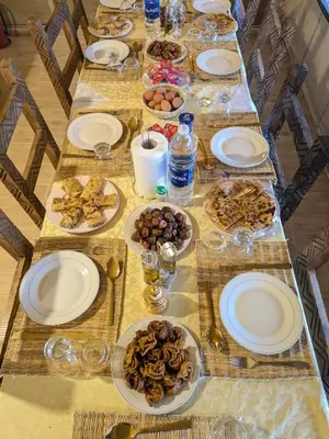 a long table topped with plates and bowls of food at Glamping Dunes Merzouga in Merzouga