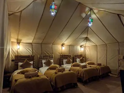 a room with four beds in a tent at Glamping Dunes Merzouga in Merzouga