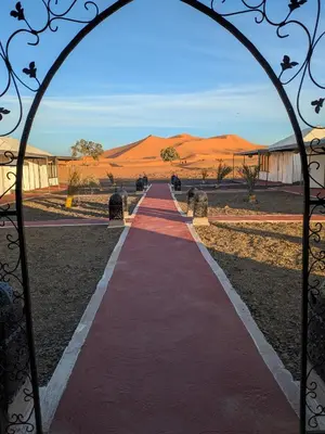 a red path through a gate in the desert at Glamping Dunes Merzouga in Merzouga